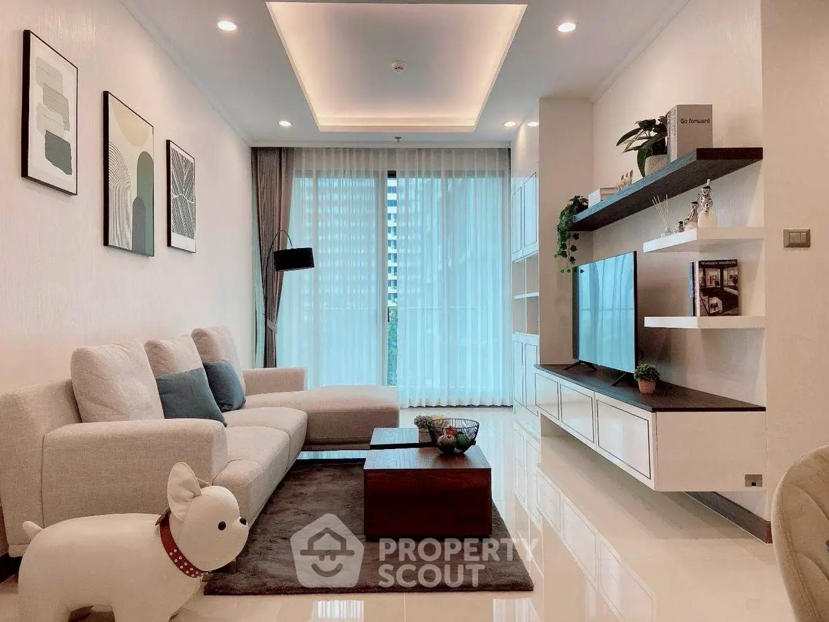 Modern living room with stylish decor, large sofa, and floor-to-ceiling windows in a contemporary apartment.