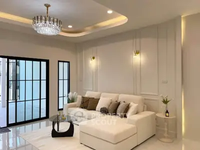 Luxurious living room with elegant chandelier and plush white sofa in modern home