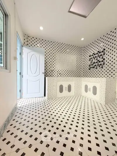 Modern kitchen with unique black and white geometric tile design and open layout.