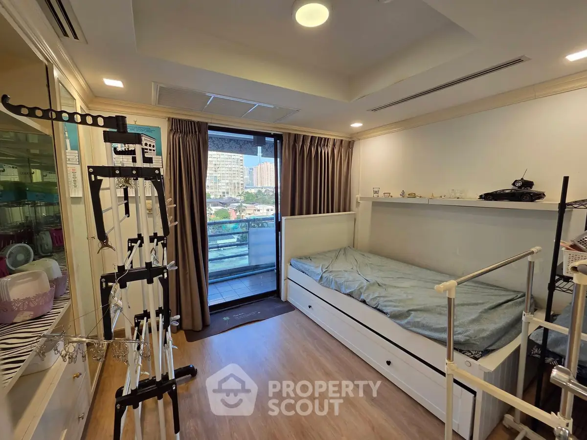 Modern bedroom with balcony view and exercise equipment, featuring sleek design and ample natural light.