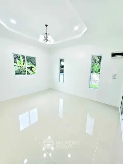 Bright and spacious living room with glossy tiled floors and modern chandelier