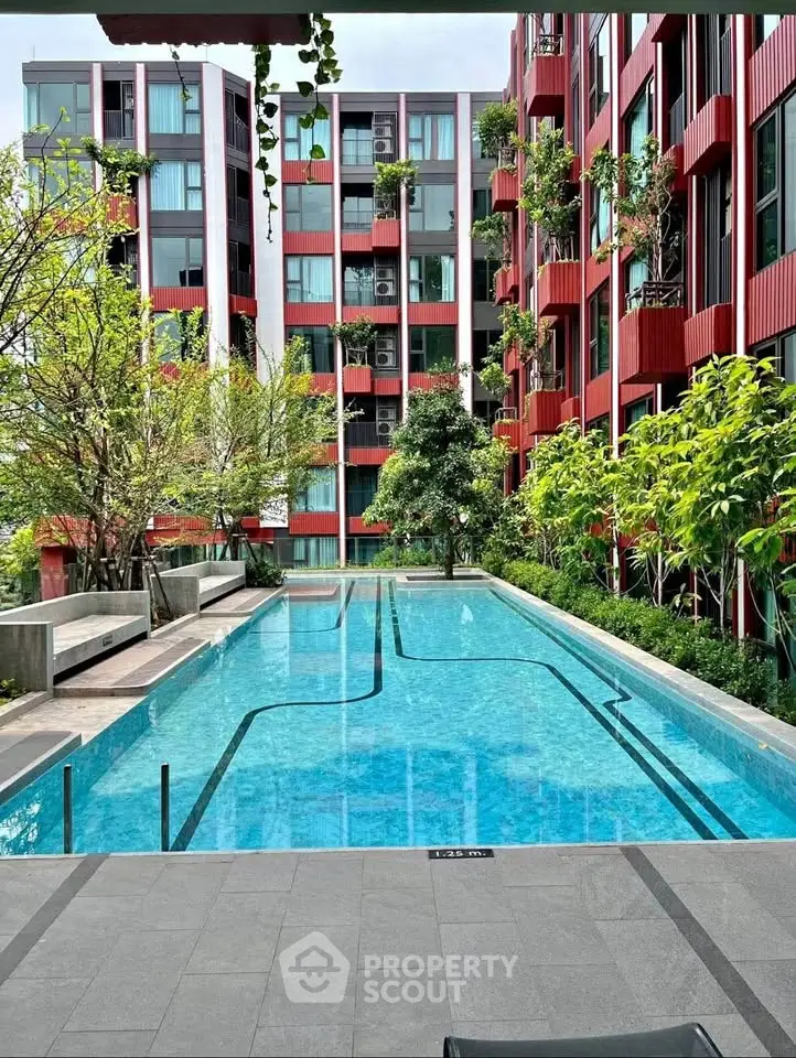 Modern apartment complex with a stunning outdoor pool and lush greenery.