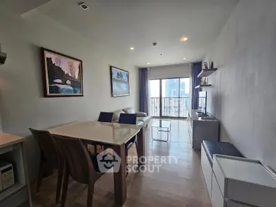 Modern living room with elegant dining area and balcony view in a stylish apartment.