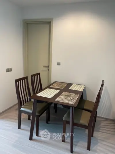 Modern dining area with sleek wooden table and chairs in a minimalist setting.