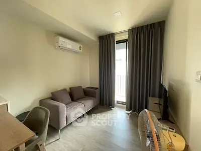 Cozy living room with modern furniture and balcony access in a stylish apartment.