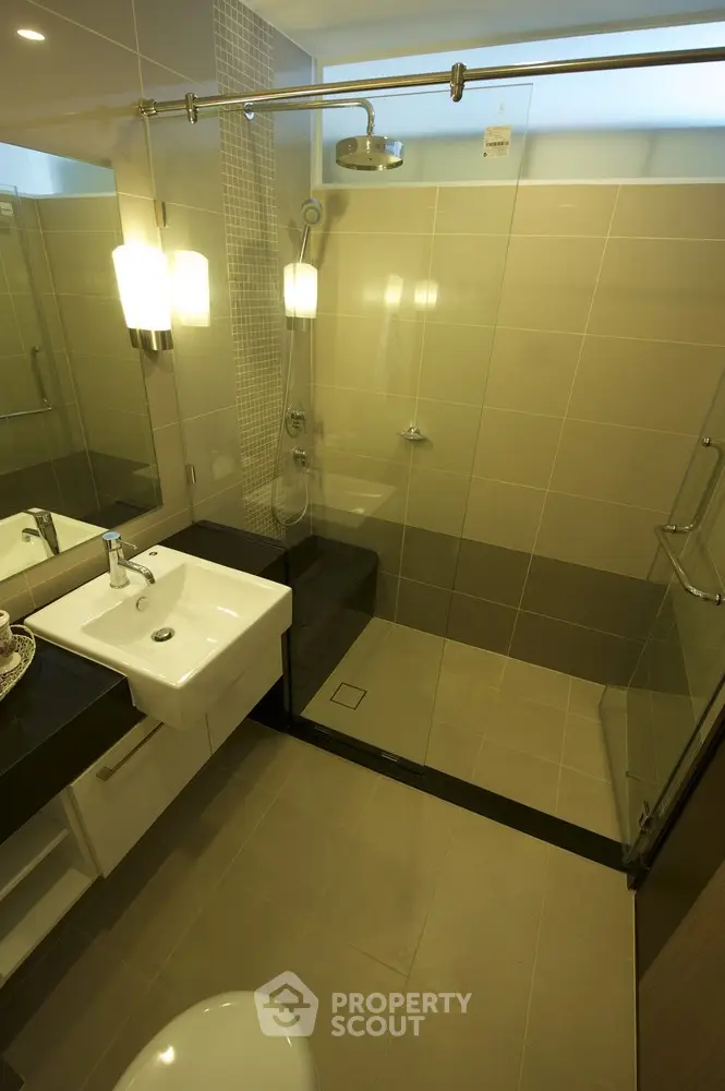 Modern bathroom with glass shower enclosure and sleek fixtures