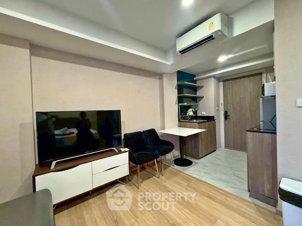 Modern living room with sleek furniture and open kitchen layout in a stylish apartment.