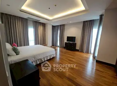 Spacious bedroom with elegant wooden flooring and modern decor