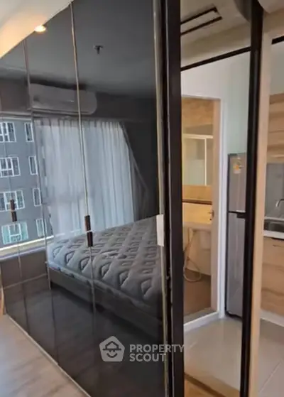 Modern bedroom with glass partition and adjacent bathroom in a stylish apartment.