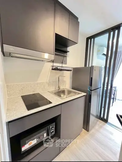 Modern compact kitchen with sleek appliances and open layout in a stylish apartment.