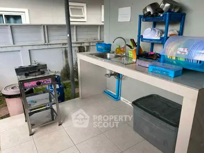 Outdoor kitchen area with gas stove and sink, perfect for alfresco dining.