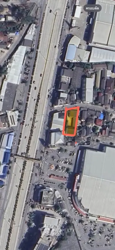 Aerial view of urban area with roads and buildings, highlighting a specific property.