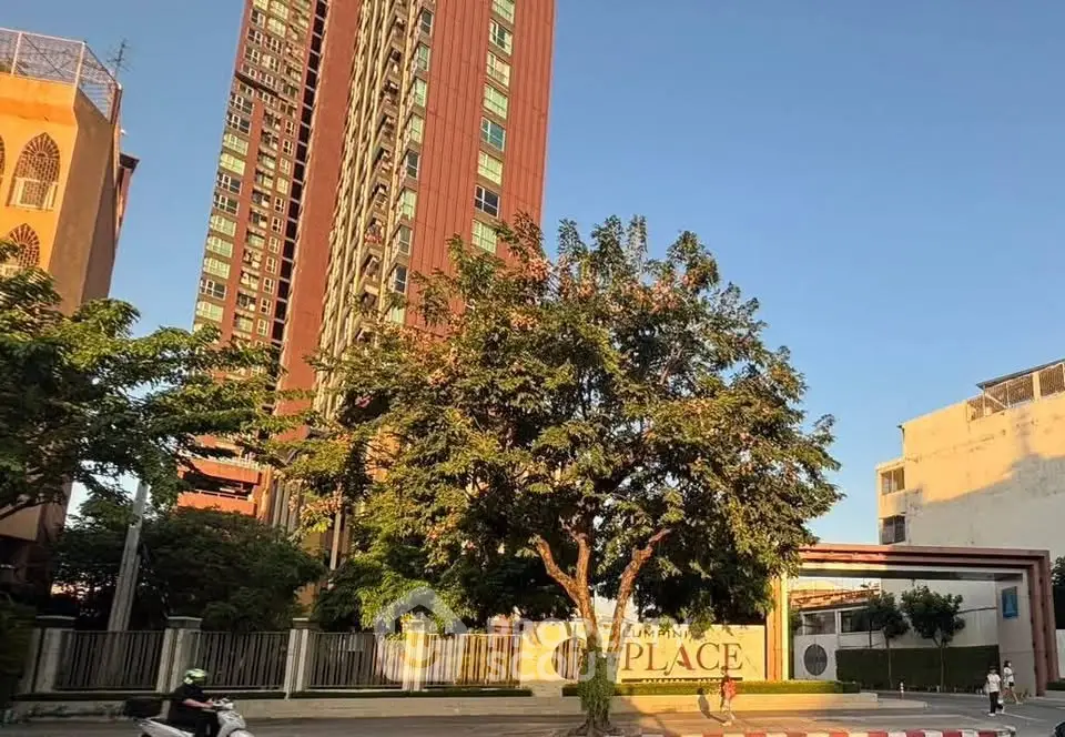 Stunning high-rise building with lush greenery and clear blue sky.