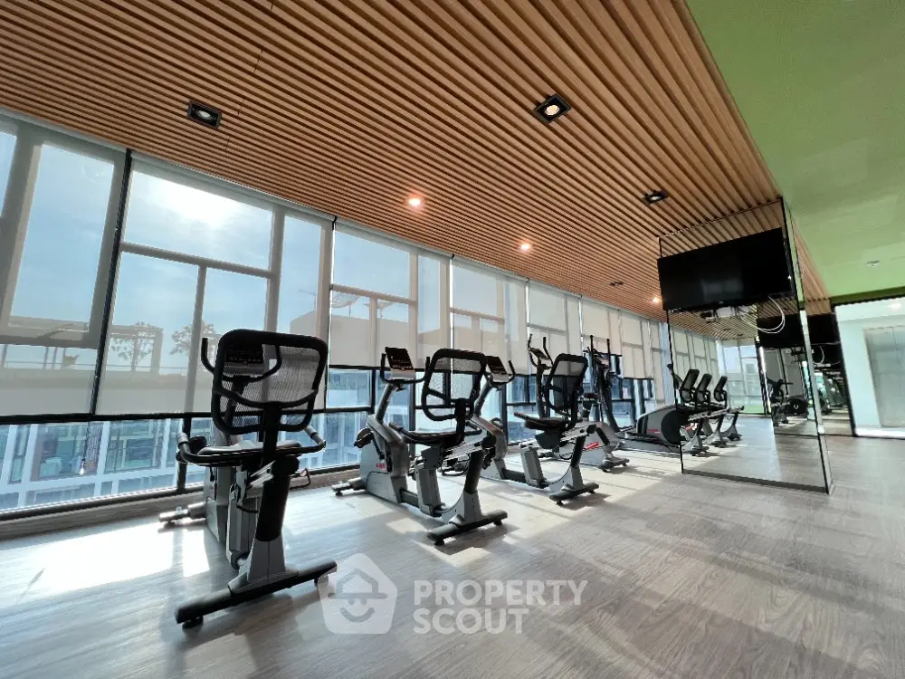 Modern gym with exercise bikes and large windows in luxury apartment building
