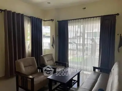 Cozy living room with natural light and comfortable seating, ideal for relaxation.