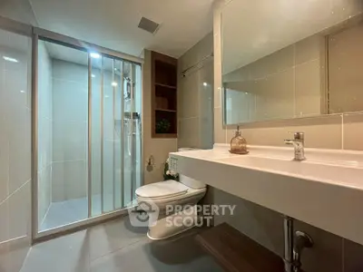 Modern bathroom with sleek design, featuring a spacious shower and elegant fixtures.