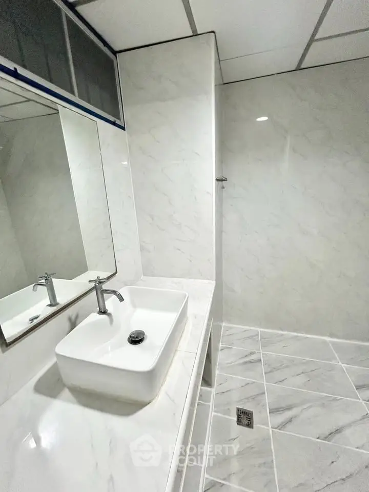 Modern bathroom with sleek white marble tiles and stylish sink