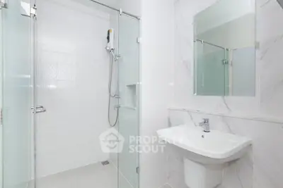 Modern bathroom with glass shower and sleek white sink