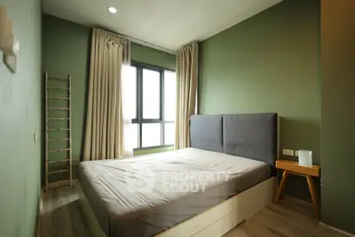 Modern bedroom with green walls, large window, and stylish decor