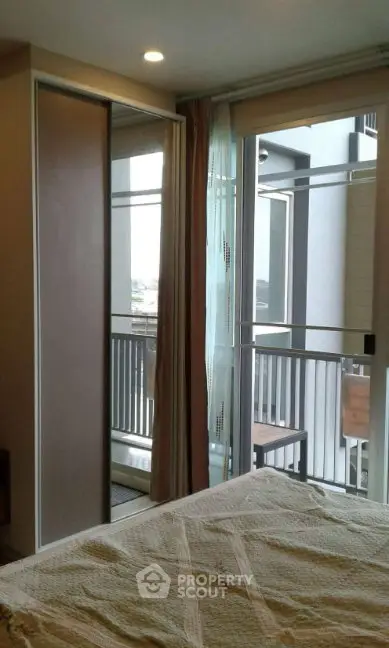 Cozy bedroom with balcony access and modern sliding door wardrobe.