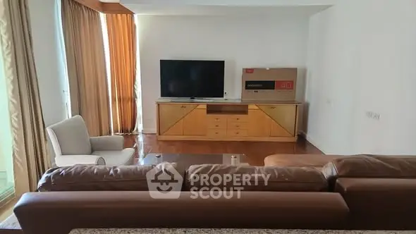 Spacious living room with modern furniture and large TV, perfect for relaxation.