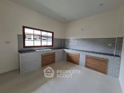 Modern kitchen with sleek cabinetry and tiled backsplash in a spacious layout.