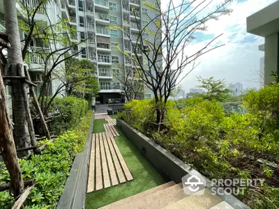 Modern apartment building with lush garden and scenic city view