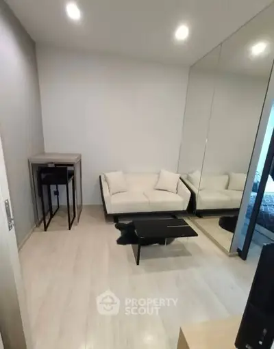 Modern living room with sleek design and mirrored wall enhancing space