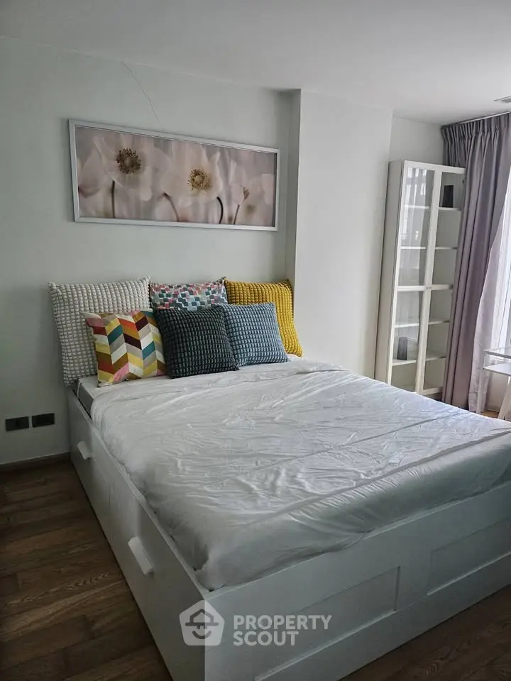 Modern bedroom with stylish decor and ample natural light, featuring a cozy bed and elegant furnishings.