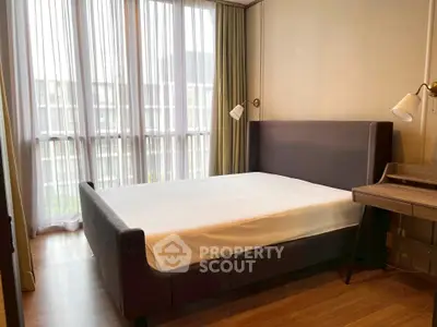 Modern bedroom with large windows and stylish furnishings in a contemporary apartment.