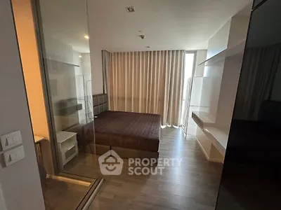Modern bedroom with glass partition and floor-to-ceiling curtains