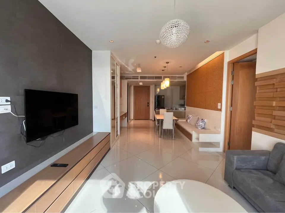 Modern living room with sleek design and open layout, featuring stylish furniture and ambient lighting.