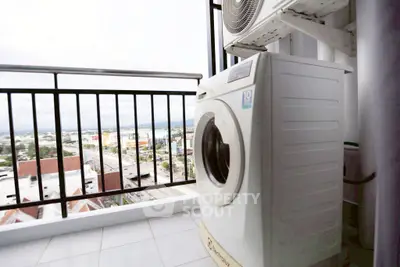 High-rise balcony with washing machine and city view, perfect for urban living.