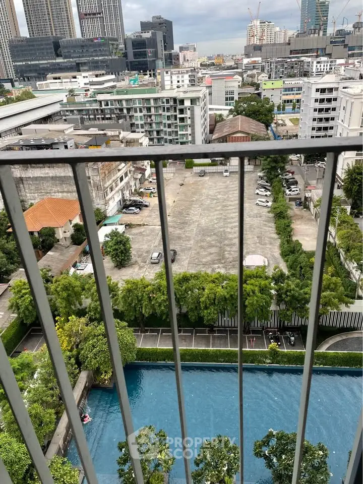 Stunning cityscape view from high-rise balcony overlooking pool and urban skyline.