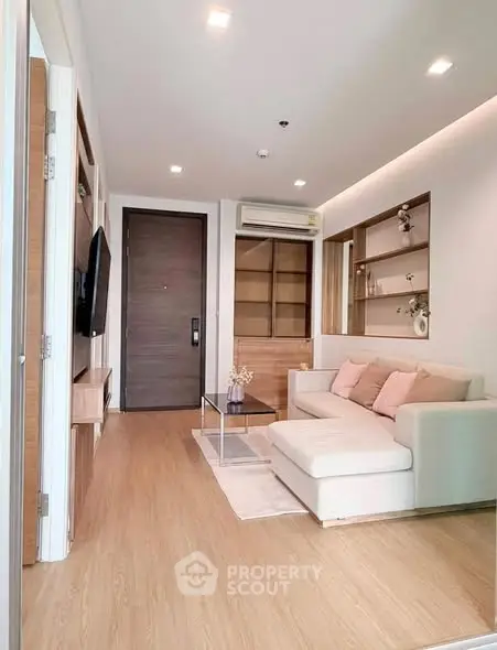 Modern living room with cozy sofa, wooden flooring, and built-in shelves in a stylish apartment.