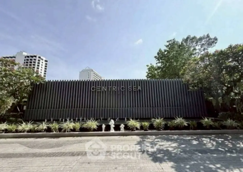 Modern building entrance with sleek design and lush greenery at Centric Sea.