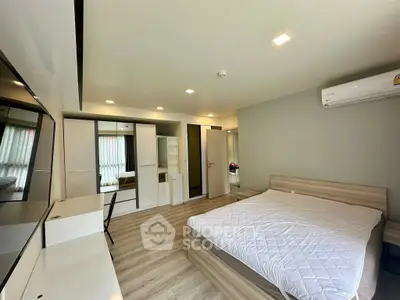 Spacious modern bedroom with stylish decor and ample natural light