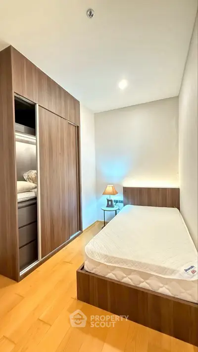Modern bedroom with sleek wooden wardrobe and minimalist design