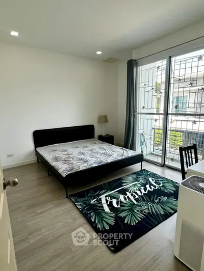 Spacious bedroom with modern decor and large window for natural light