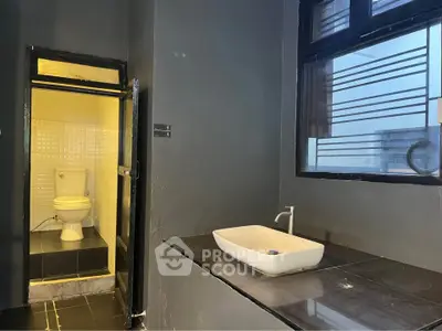 Modern bathroom with sleek black tiles and stylish white fixtures