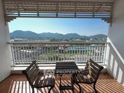 Charming balcony with mountain view and cozy seating area, perfect for relaxation.