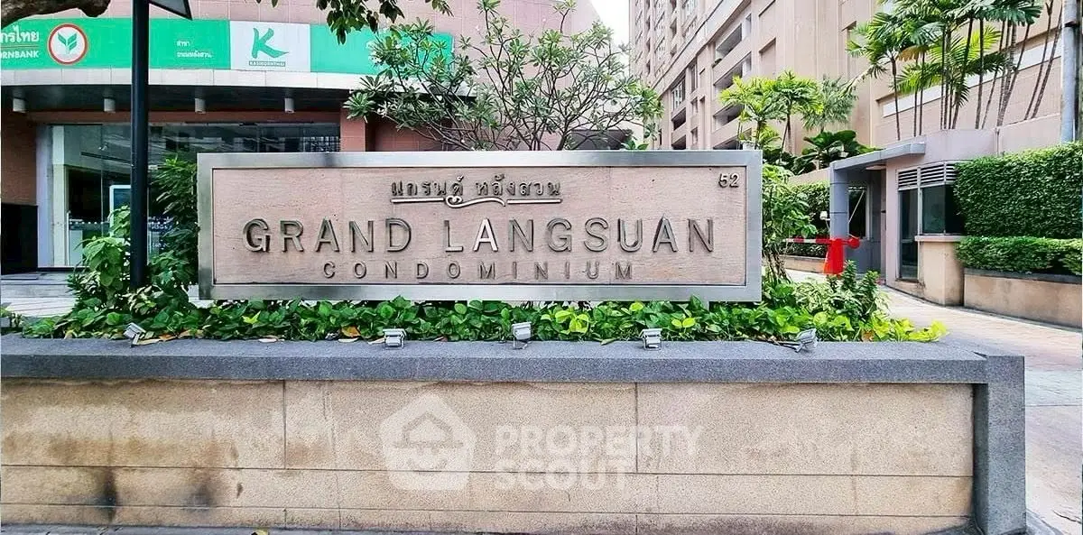 Grand Langsuan Condominium entrance with modern signage and lush greenery.