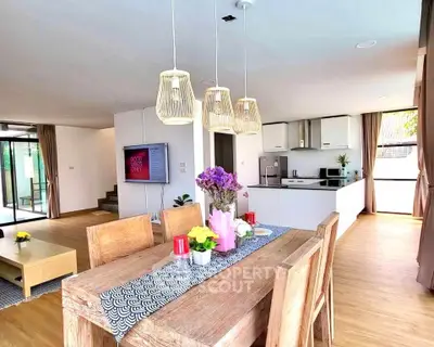 Spacious open-layout living and dining area with modern kitchen and natural light.