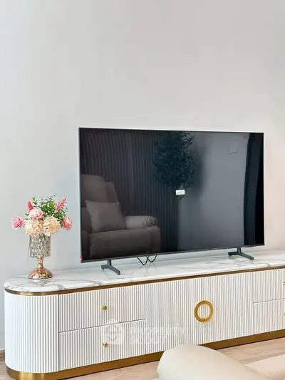 Modern living room with sleek TV on stylish console and elegant decor