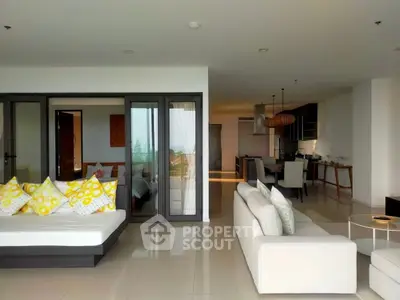 Luxurious open-plan living room with modern decor and stunning ocean view.