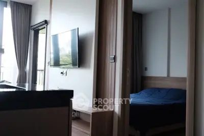 Modern apartment interior with sleek TV setup and cozy bedroom view.