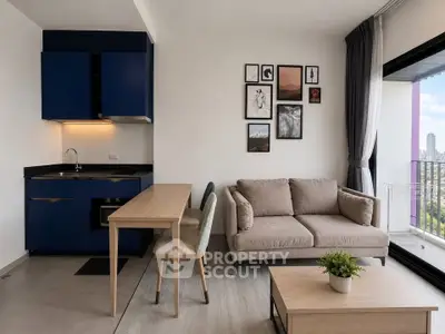 Modern living room with stylish decor, blue kitchen cabinets, and large window offering city views.