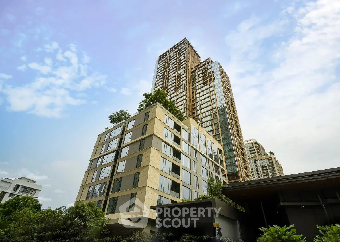 Modern high-rise residential building with lush greenery and clear blue sky.