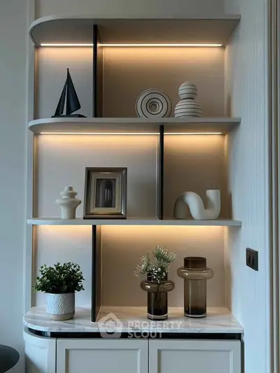 Elegant modern shelving with decorative items and ambient lighting in a stylish interior space.