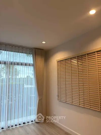 Bright room with large window and elegant curtains, perfect for a cozy living space.